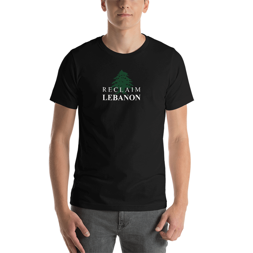 A black t-shirt with a green cedar tree with text overlayed on top of it saying 'Reclaim Lebanon'.